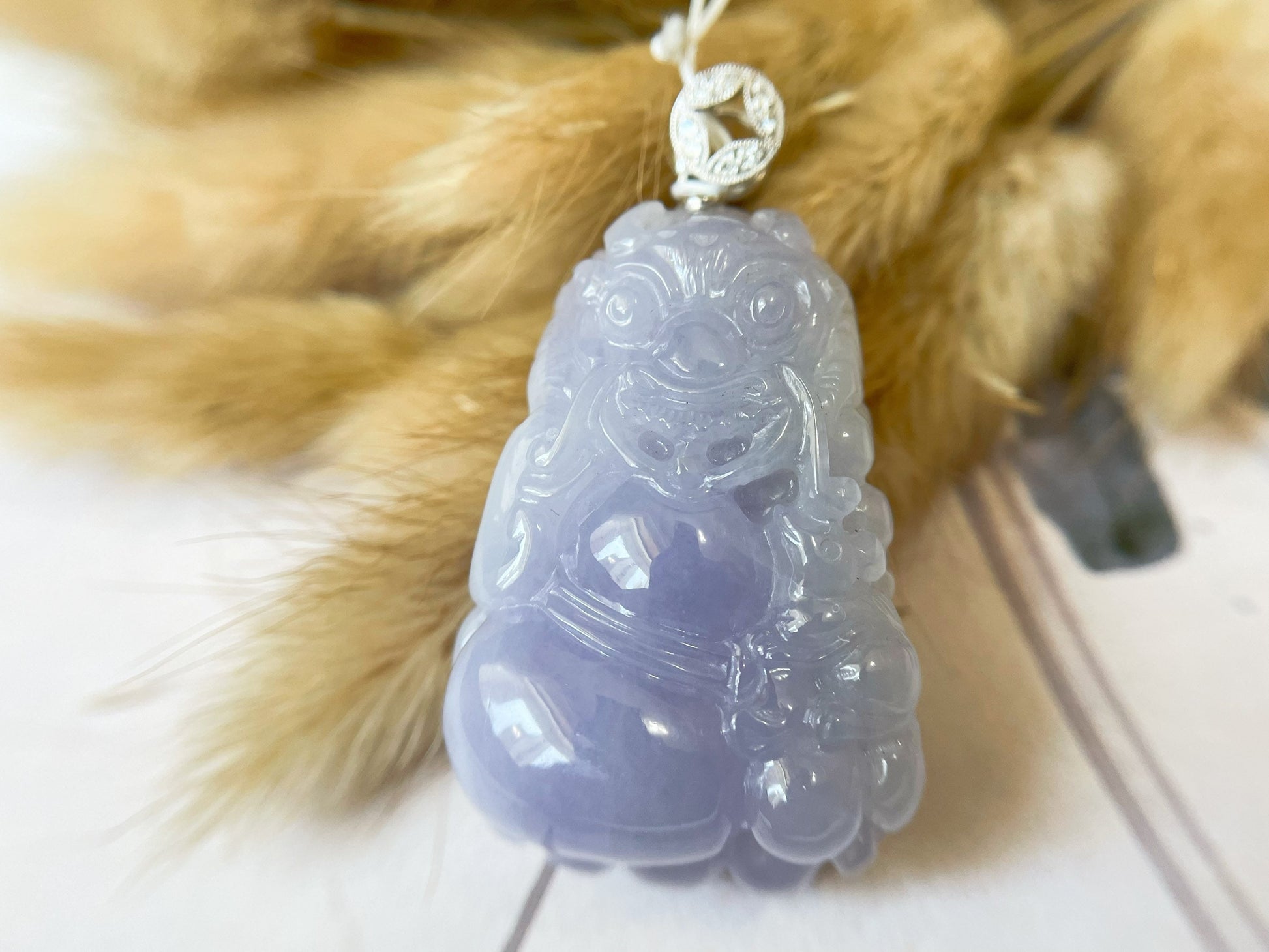 Exquisite lavender Qilin jadeite carved from 100% natural, untreated Type-A jadeite, featuring 8 sparkling diamonds set in 18K white gold. Dimensions: width 29.2 mm, height 51.6 mm, thickness 19.6 mm; total weight 218.54 ct. The icy texture and intricate carving symbolize good luck, prosperity, and happiness in Asian mythology, making it a meaningful accessory for any occasion.