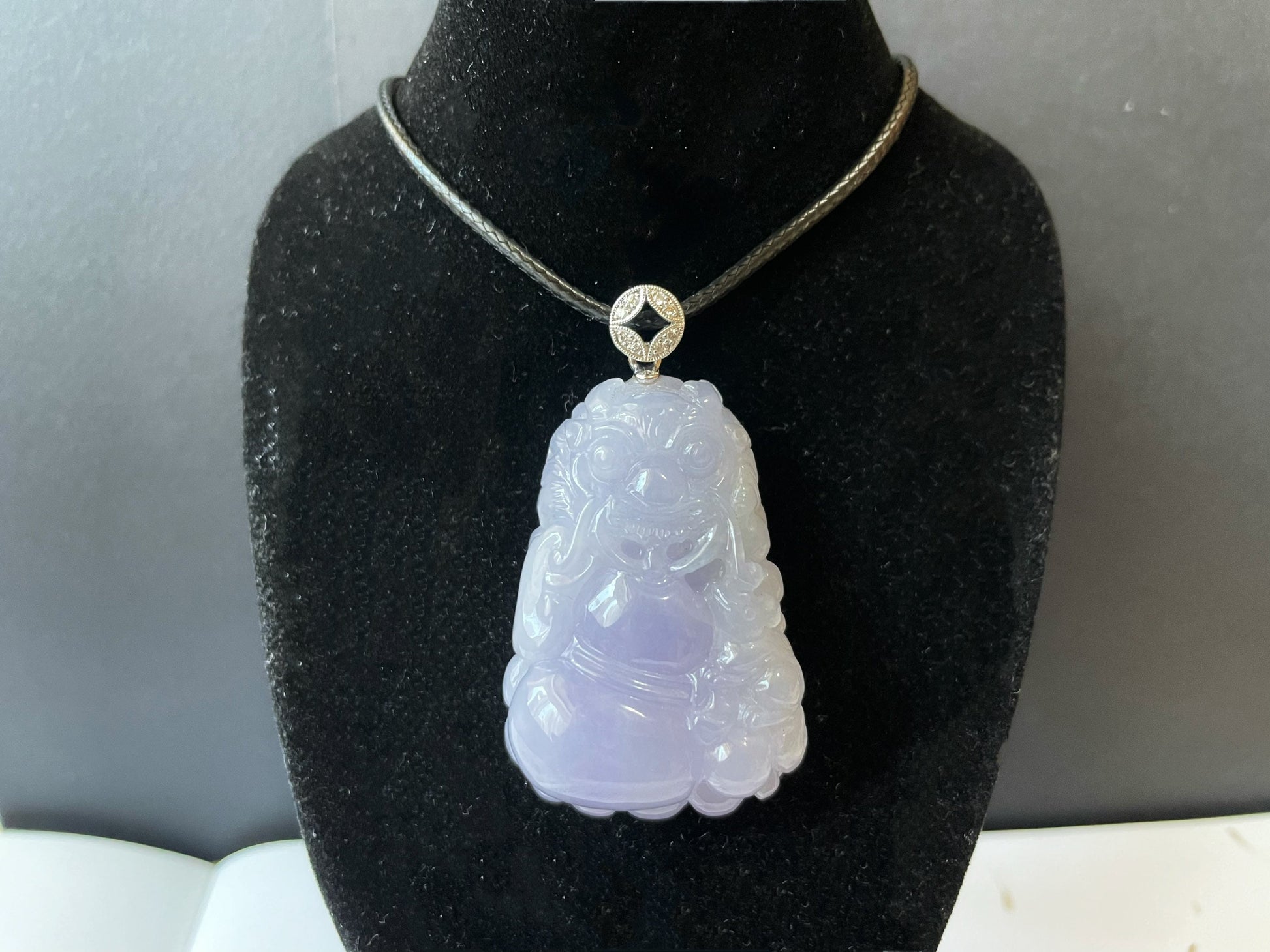 Exquisite lavender Qilin jadeite carved from 100% natural, untreated Type-A jadeite, featuring 8 sparkling diamonds set in 18K white gold. Dimensions: width 29.2 mm, height 51.6 mm, thickness 19.6 mm; total weight 218.54 ct. The icy texture and intricate carving symbolize good luck, prosperity, and happiness in Asian mythology, making it a meaningful accessory for any occasion.