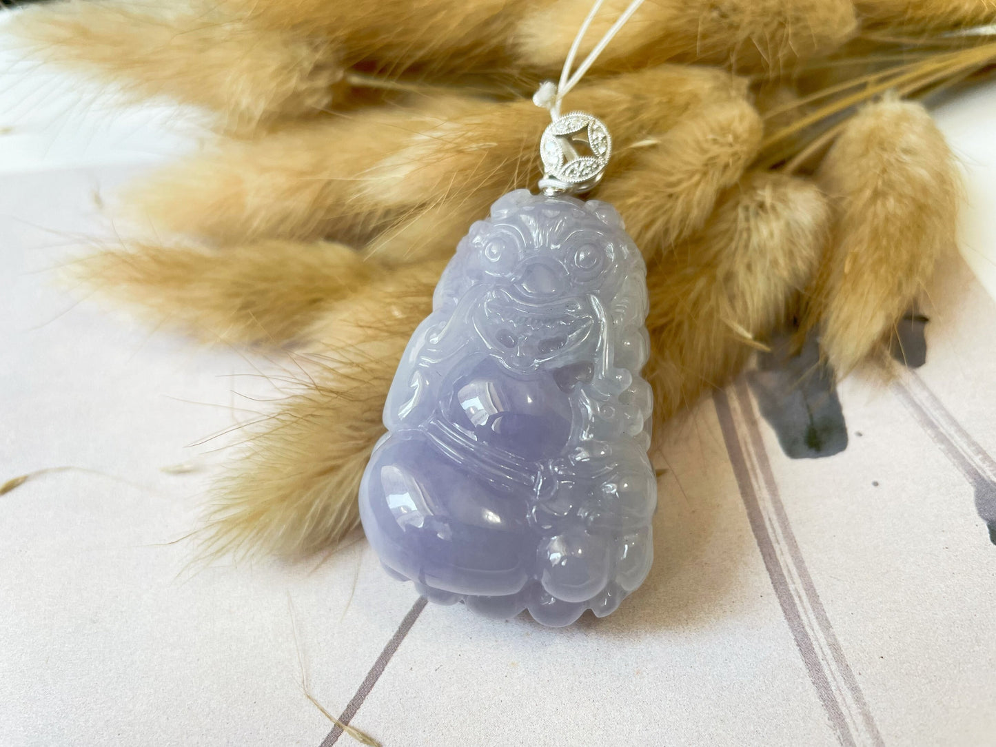 Exquisite lavender Qilin jadeite carved from 100% natural, untreated Type-A jadeite, featuring 8 sparkling diamonds set in 18K white gold. Dimensions: width 29.2 mm, height 51.6 mm, thickness 19.6 mm; total weight 218.54 ct. The icy texture and intricate carving symbolize good luck, prosperity, and happiness in Asian mythology, making it a meaningful accessory for any occasion.