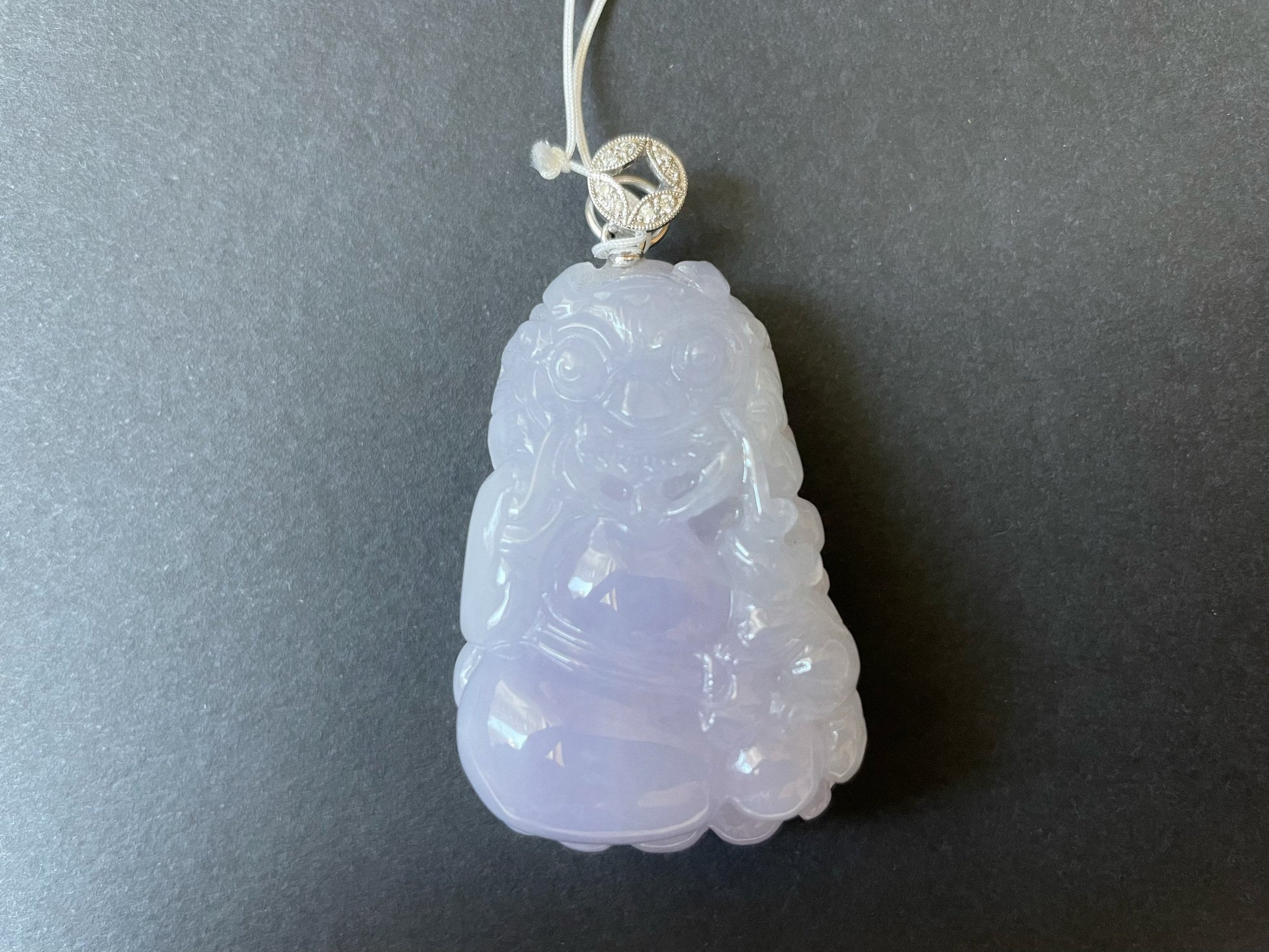 Exquisite lavender Qilin jadeite carved from 100% natural, untreated Type-A jadeite, featuring 8 sparkling diamonds set in 18K white gold. Dimensions: width 29.2 mm, height 51.6 mm, thickness 19.6 mm; total weight 218.54 ct. The icy texture and intricate carving symbolize good luck, prosperity, and happiness in Asian mythology, making it a meaningful accessory for any occasion.