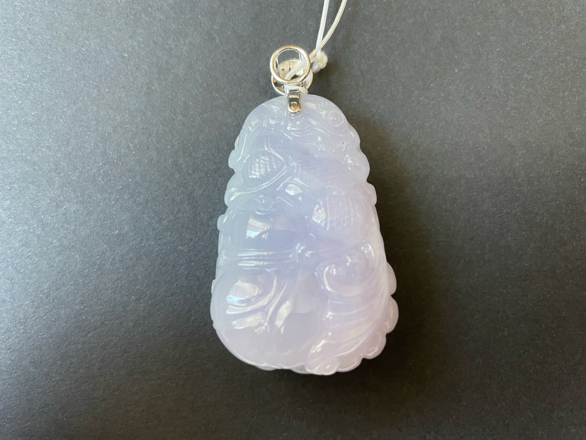 Exquisite lavender Qilin jadeite carved from 100% natural, untreated Type-A jadeite, featuring 8 sparkling diamonds set in 18K white gold. Dimensions: width 29.2 mm, height 51.6 mm, thickness 19.6 mm; total weight 218.54 ct. The icy texture and intricate carving symbolize good luck, prosperity, and happiness in Asian mythology, making it a meaningful accessory for any occasion.
