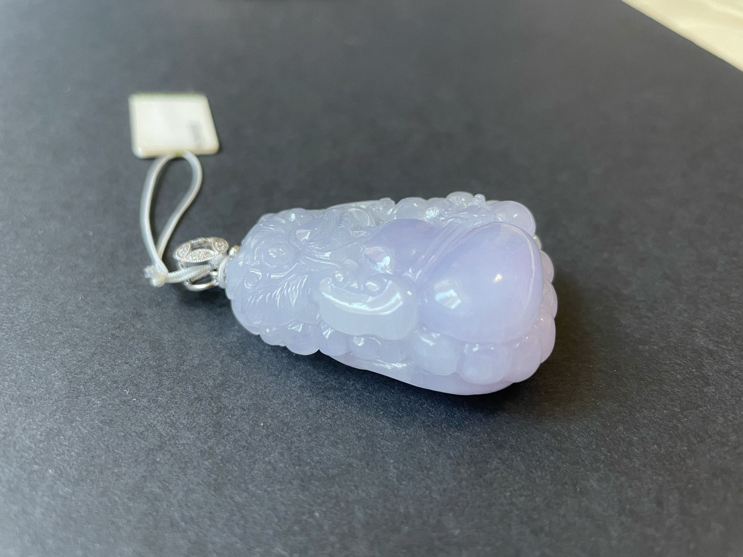 Exquisite lavender Qilin jadeite carved from 100% natural, untreated Type-A jadeite, featuring 8 sparkling diamonds set in 18K white gold. Dimensions: width 29.2 mm, height 51.6 mm, thickness 19.6 mm; total weight 218.54 ct. The icy texture and intricate carving symbolize good luck, prosperity, and happiness in Asian mythology, making it a meaningful accessory for any occasion.