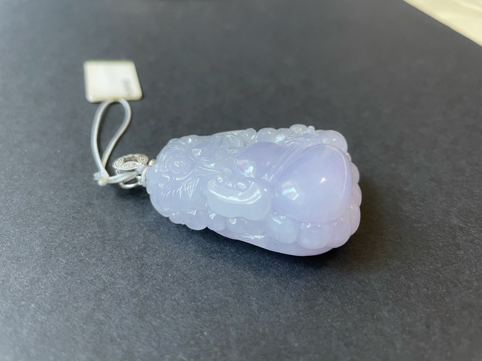 Exquisite lavender Qilin jadeite carved from 100% natural, untreated Type-A jadeite, featuring 8 sparkling diamonds set in 18K white gold. Dimensions: width 29.2 mm, height 51.6 mm, thickness 19.6 mm; total weight 218.54 ct. The icy texture and intricate carving symbolize good luck, prosperity, and happiness in Asian mythology, making it a meaningful accessory for any occasion.