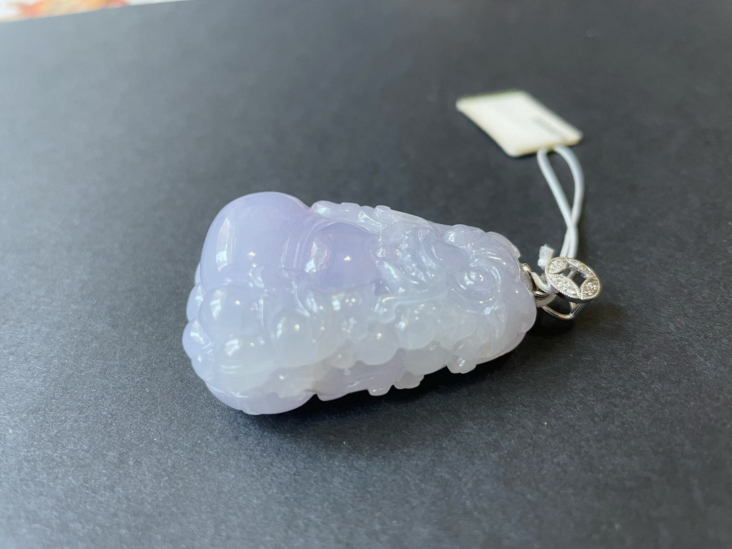 Exquisite lavender Qilin jadeite carved from 100% natural, untreated Type-A jadeite, featuring 8 sparkling diamonds set in 18K white gold. Dimensions: width 29.2 mm, height 51.6 mm, thickness 19.6 mm; total weight 218.54 ct. The icy texture and intricate carving symbolize good luck, prosperity, and happiness in Asian mythology, making it a meaningful accessory for any occasion.