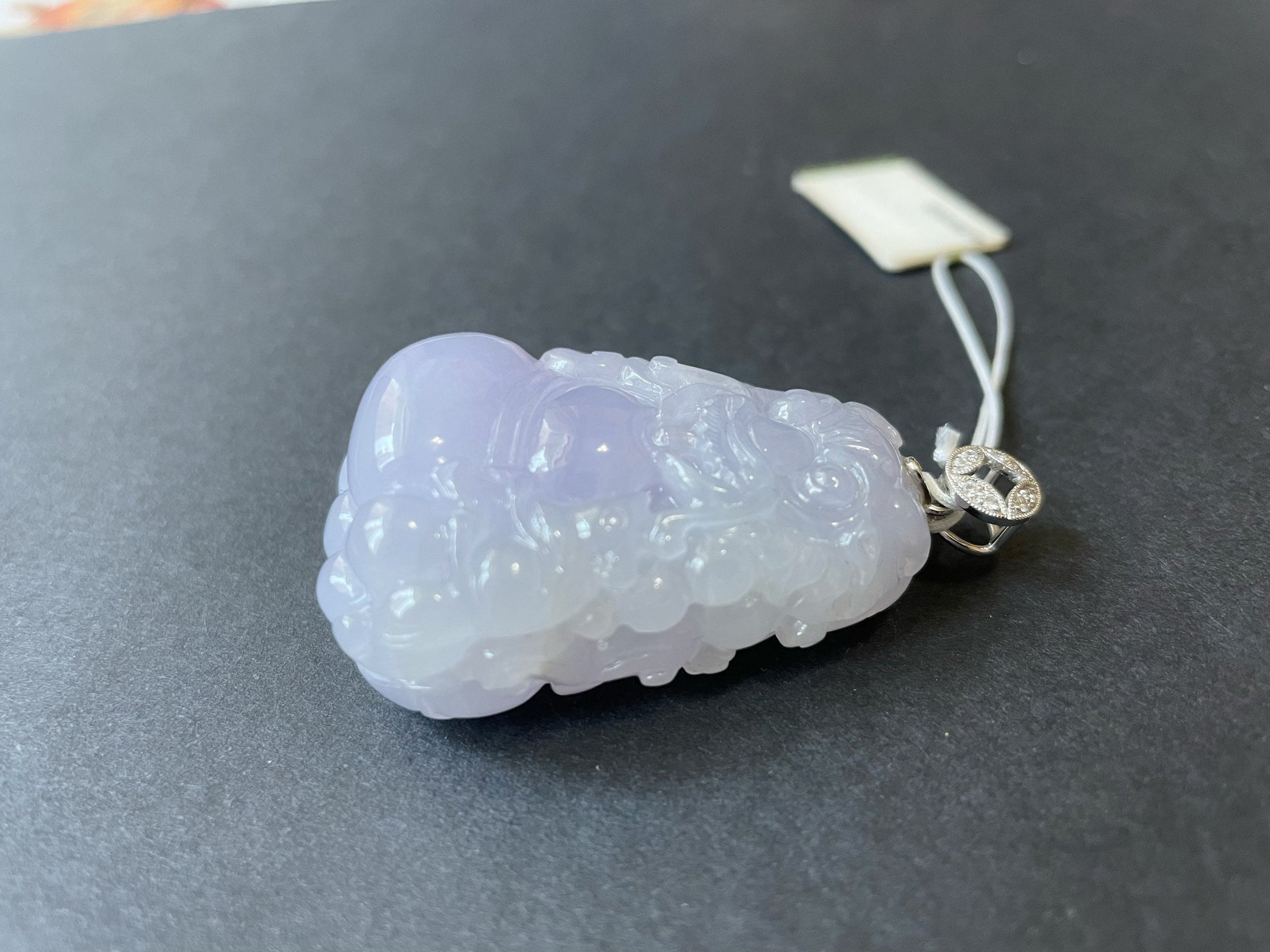 Exquisite lavender Qilin jadeite carved from 100% natural, untreated Type-A jadeite, featuring 8 sparkling diamonds set in 18K white gold. Dimensions: width 29.2 mm, height 51.6 mm, thickness 19.6 mm; total weight 218.54 ct. The icy texture and intricate carving symbolize good luck, prosperity, and happiness in Asian mythology, making it a meaningful accessory for any occasion.